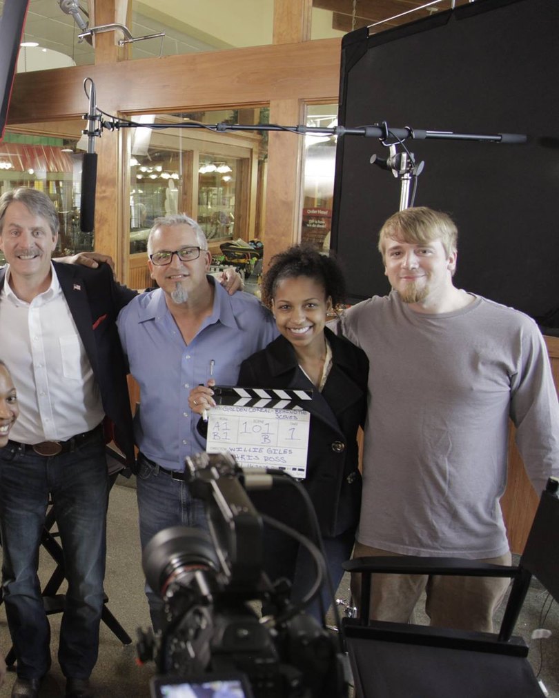 Chelsea with the crew and a slate on a Golden Corral film set
